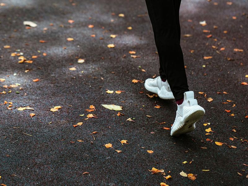 Person practicing cardio outdoors with sunrise background.